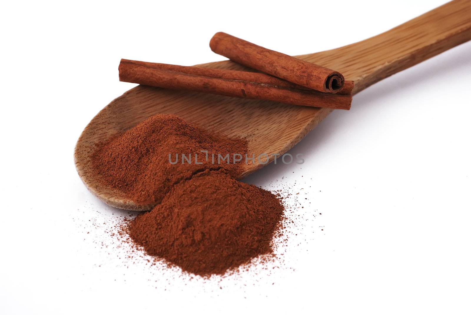 wooden spoon with cinnamon and a few tubes of cinnamon