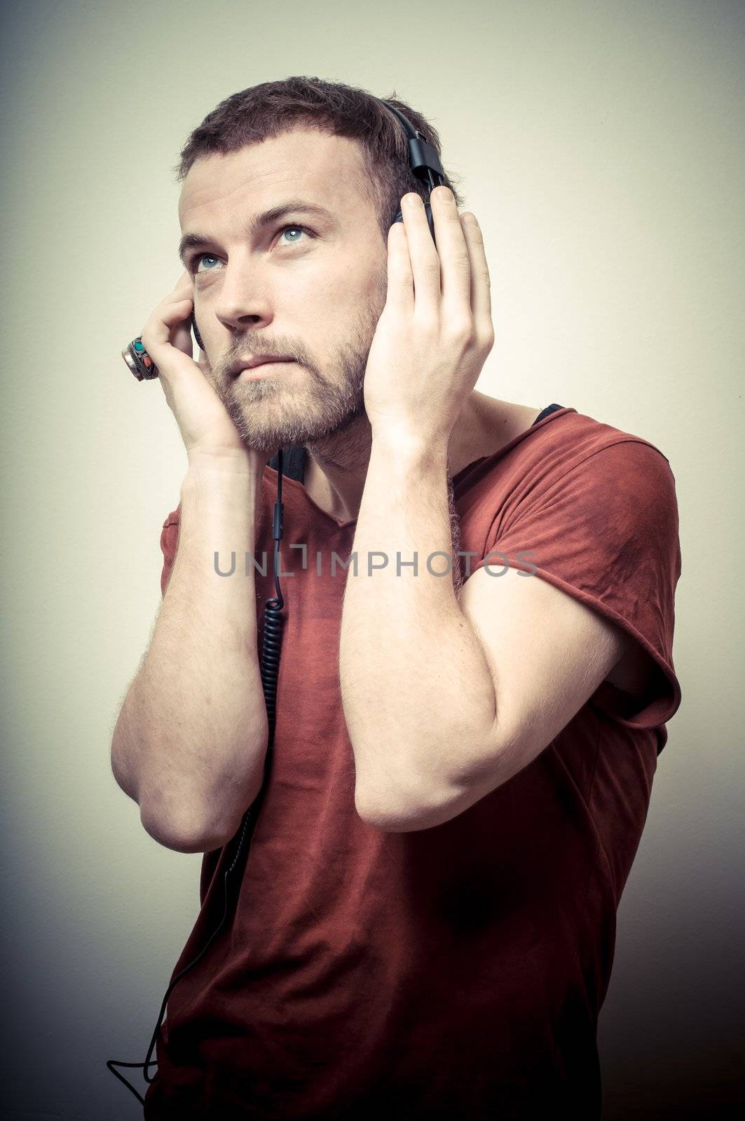 vintage portrait of fashion guy with headphones on gray background