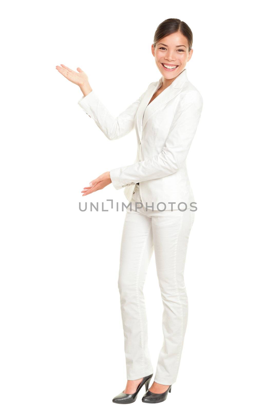 Business woman showing and presenting something standing in white suit in full body. Mixed race Chinese Asian / Caucasian businesswoman isolated on white background.