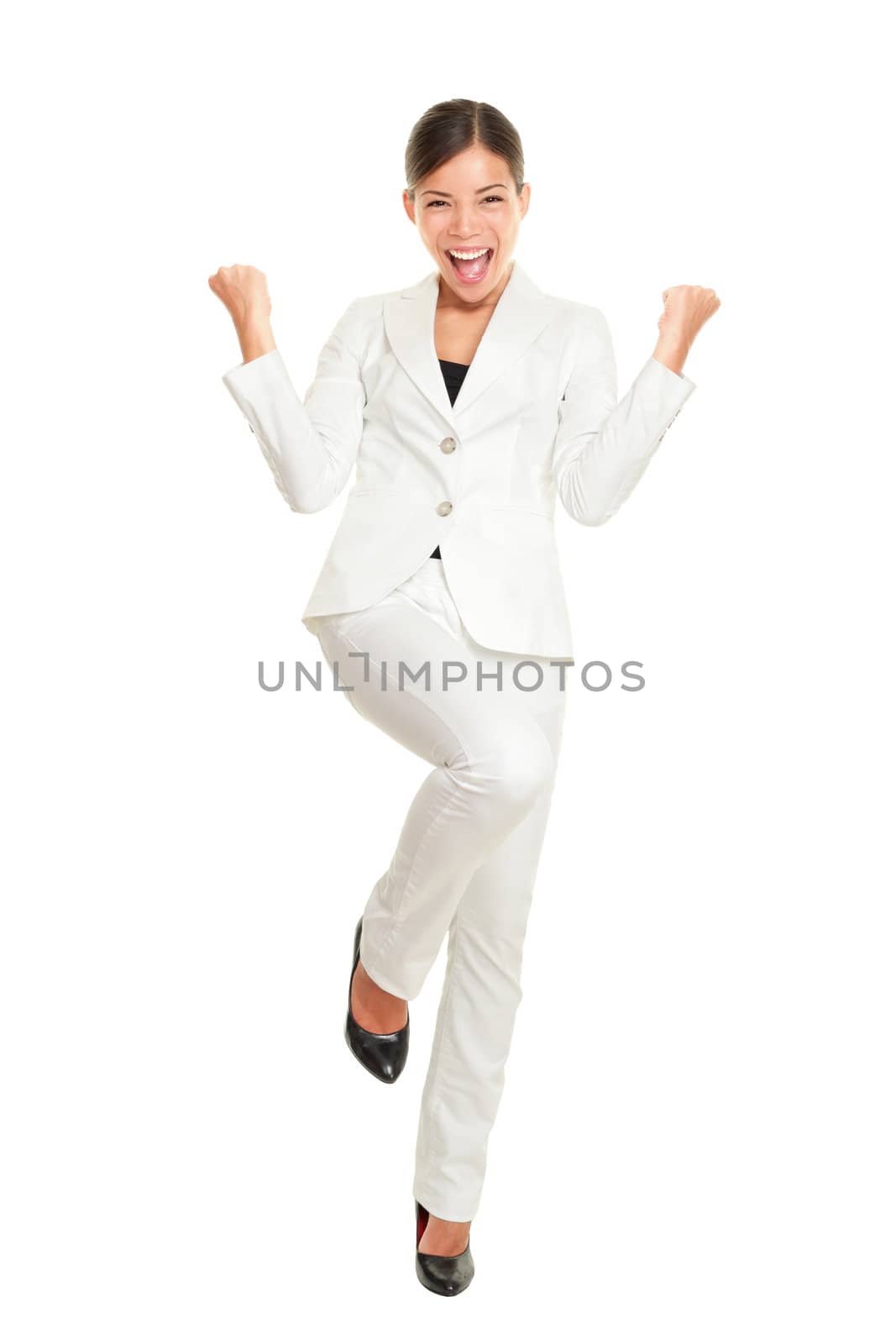 Business woman celebrating happy and cheerful in white suit in full body. Cheering winner gesturing in joyful dance over success. Young multiracial Chinese Asian and Caucasian businesswoman isolated on white background.