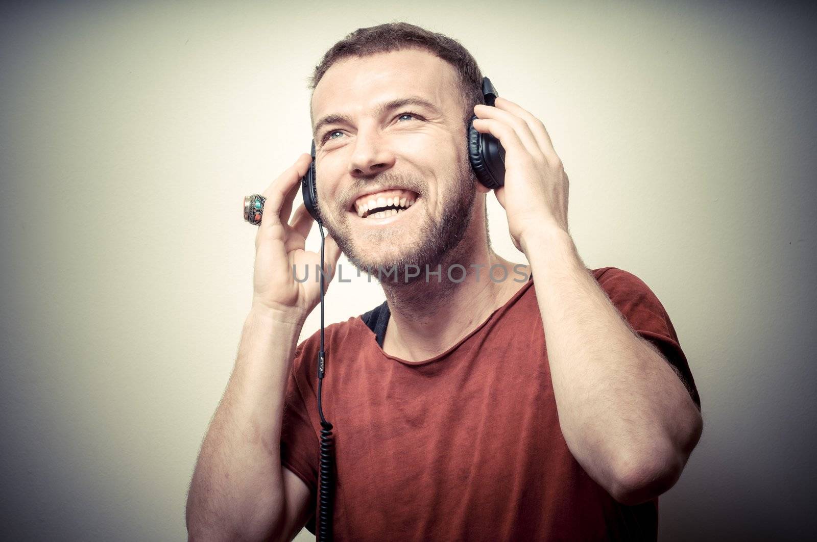 vintage portrait of fashion smiling guy with headphones on gray background