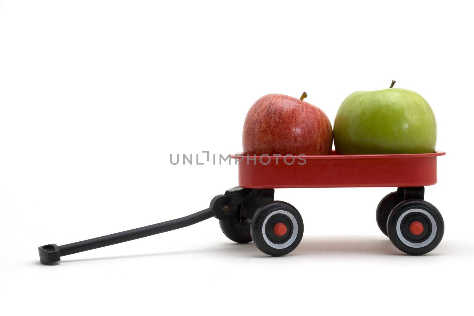 Green and red apple in a small red wagon.