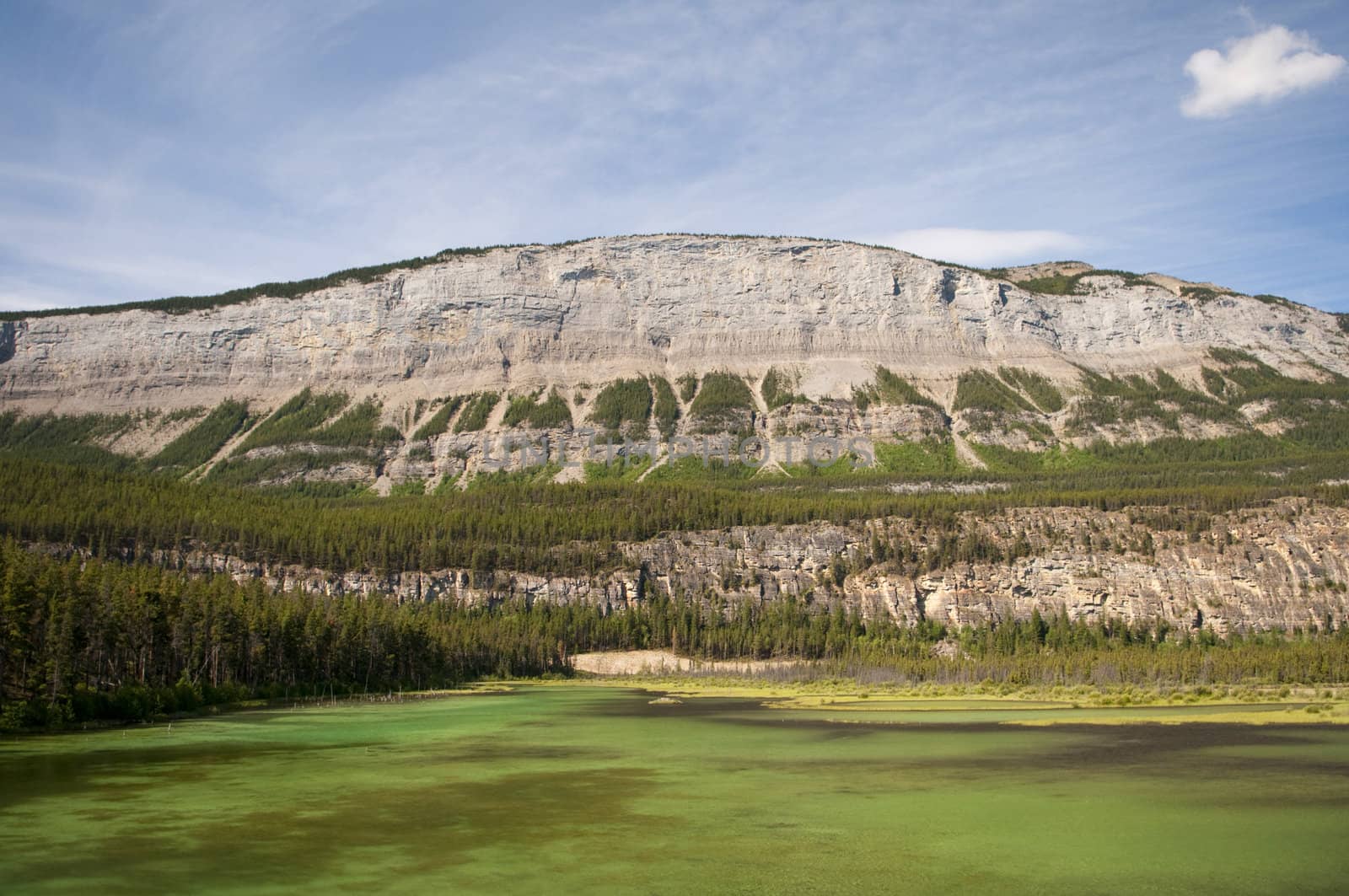 Extreme color in the lake in Jasper National Park with mountain range in the background