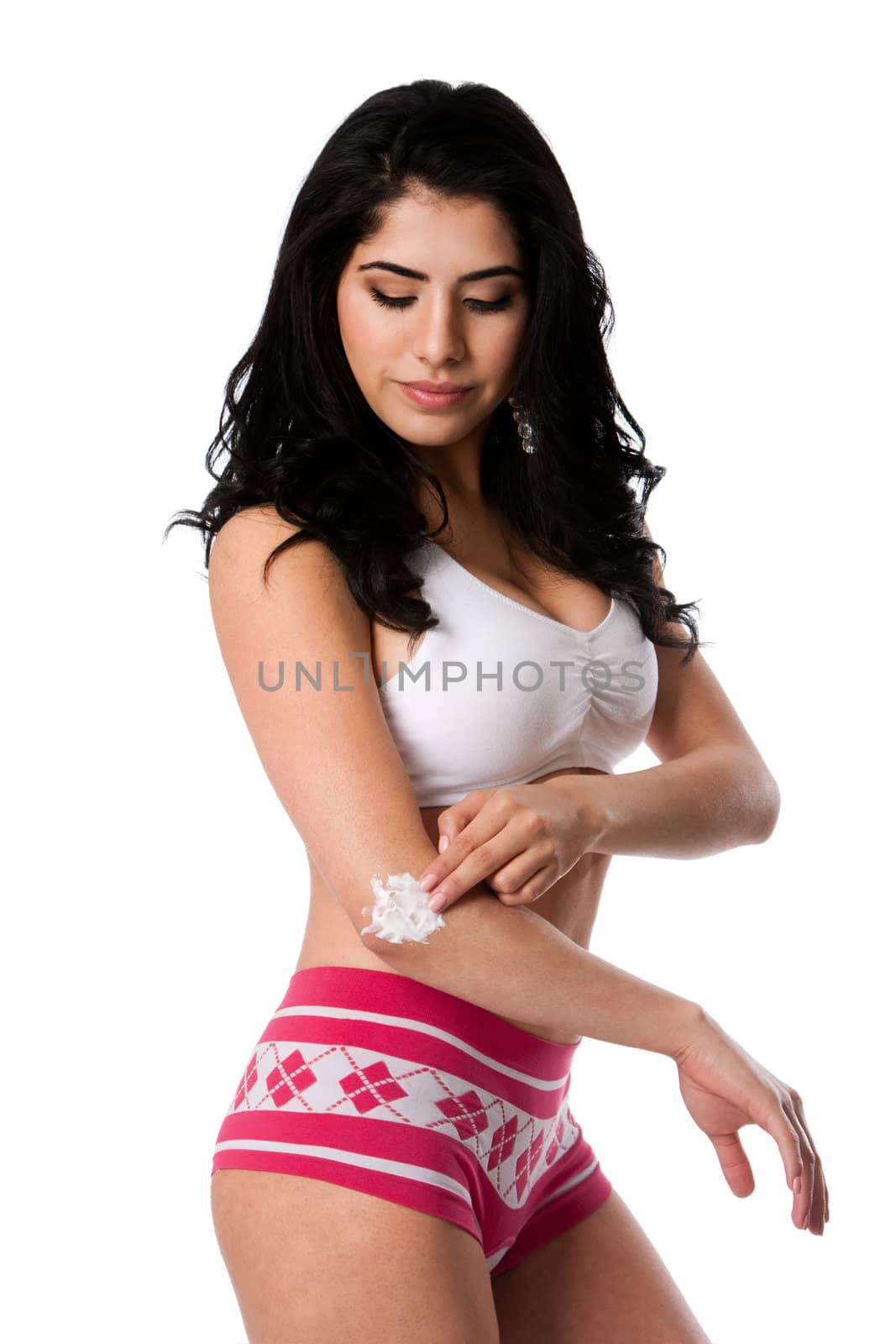 Beautiful young woman applying exfoliating moisturizing cream on dry elbow skin, isolated.