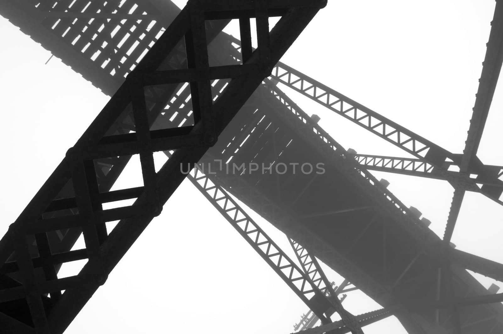 High contrast abstract image of steel girders used in a train bridge on a foggy morning