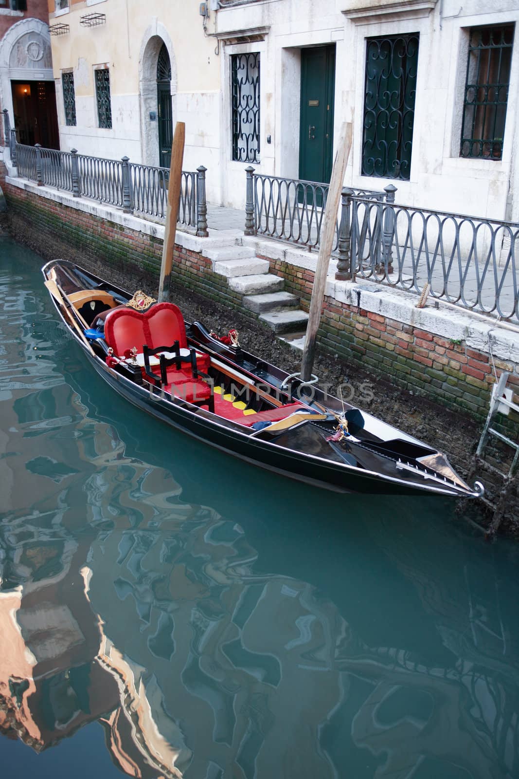 Empty gondola tied to building wall on a canal in Venice, Italy