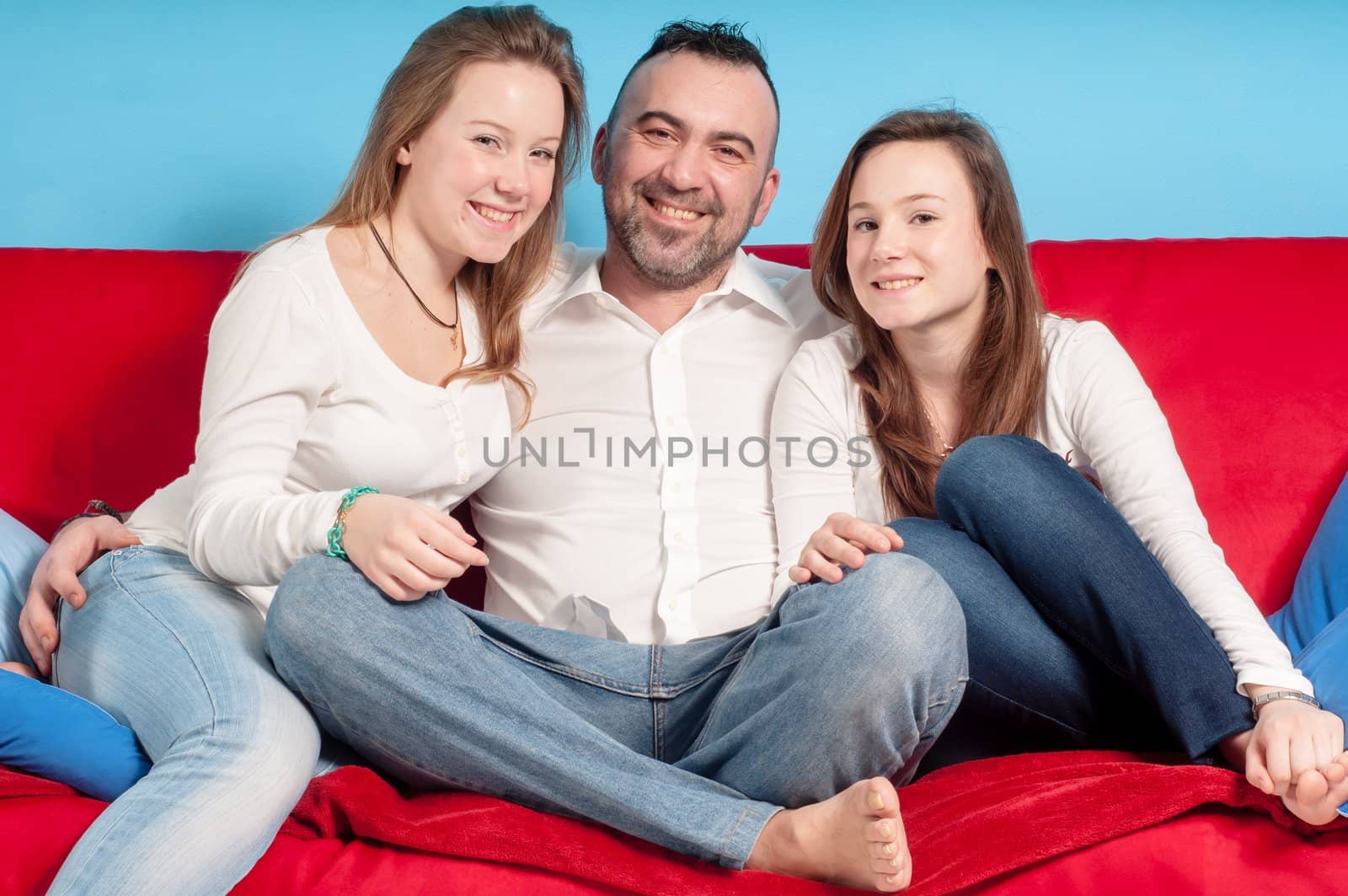 happy father and daughters on the couch in the living room