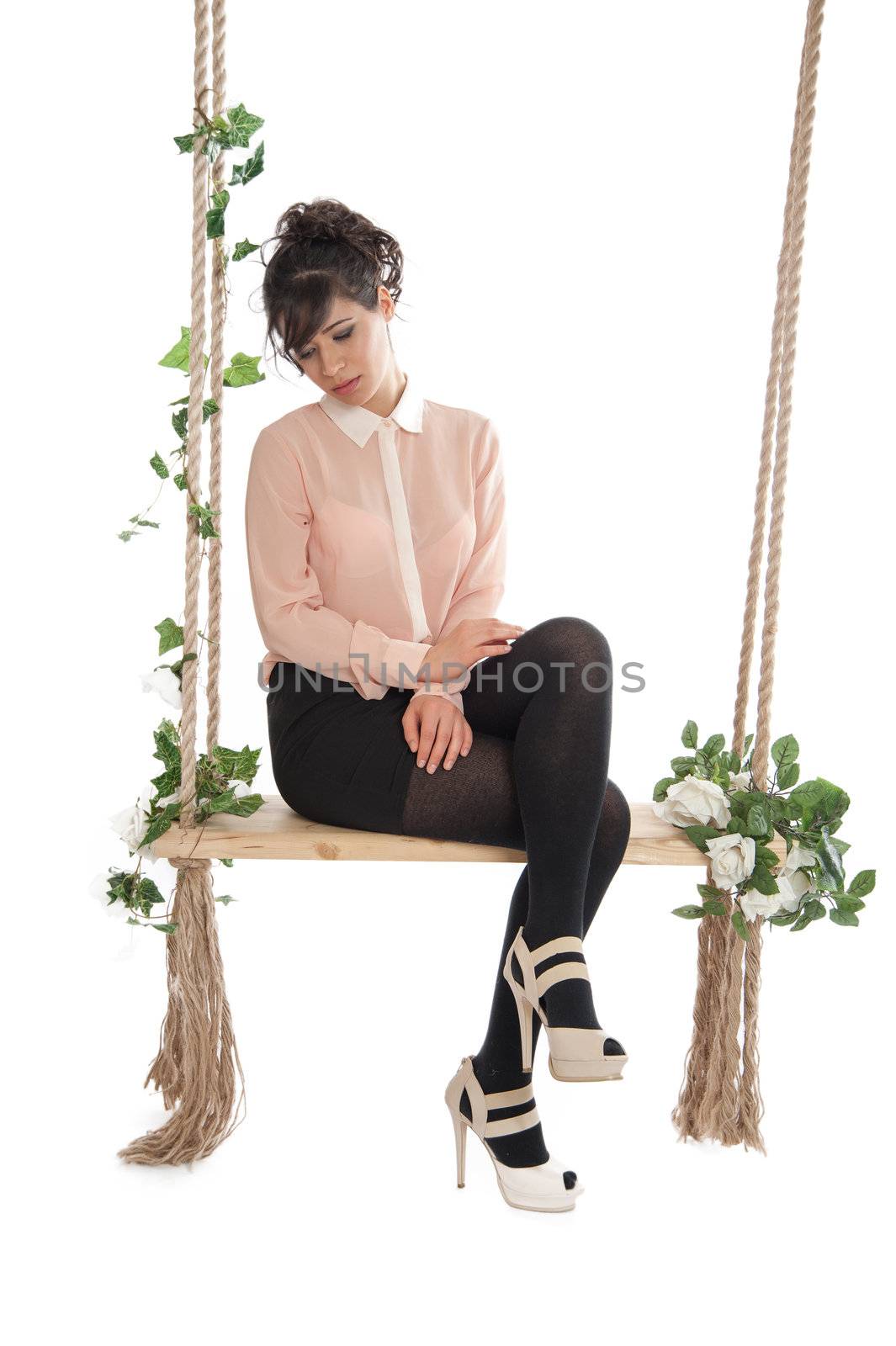 A woman in a pink blouse sitting on a swing isolated white background