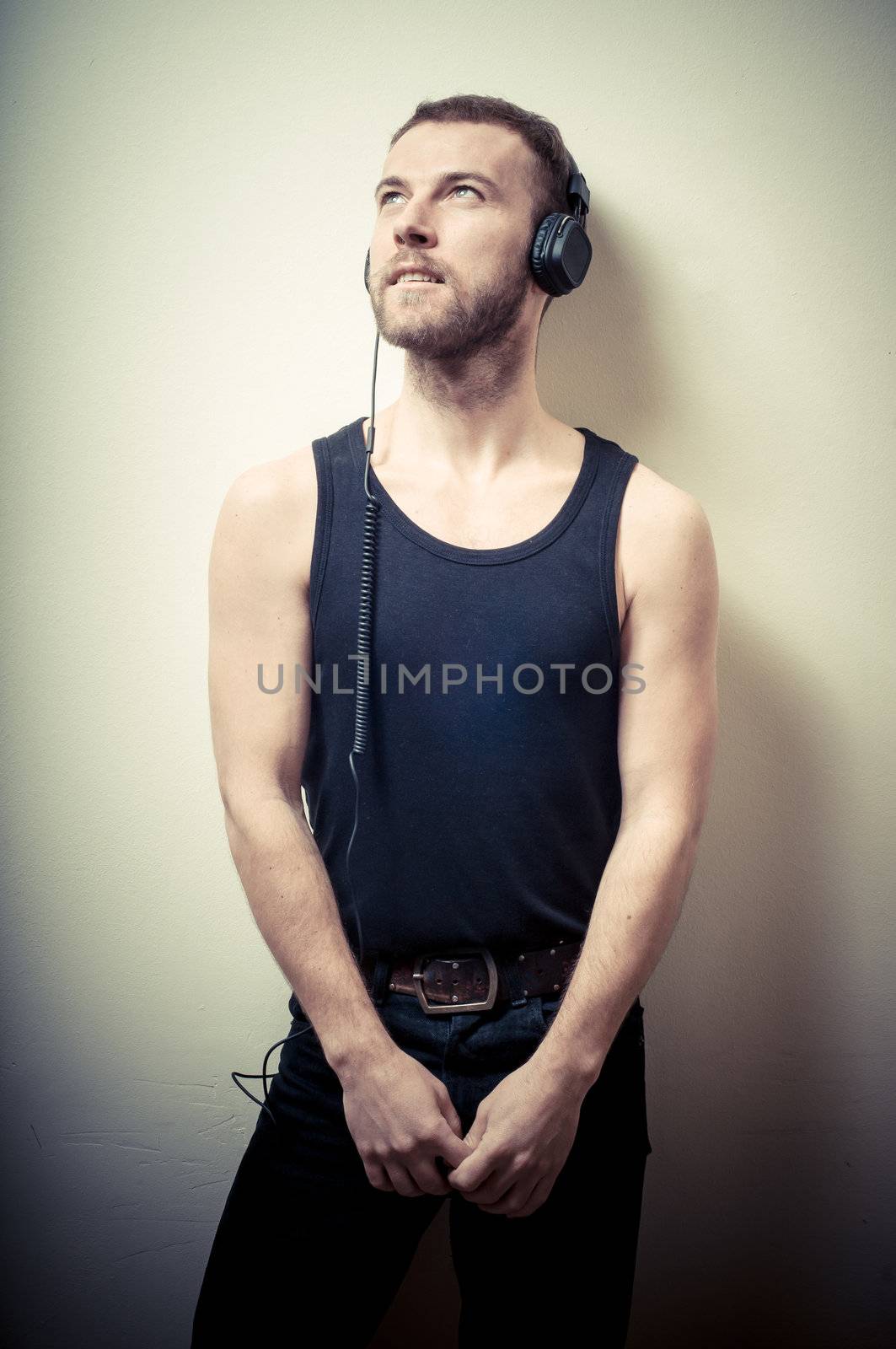 vintage portrait of fashion guy with headphones on gray background