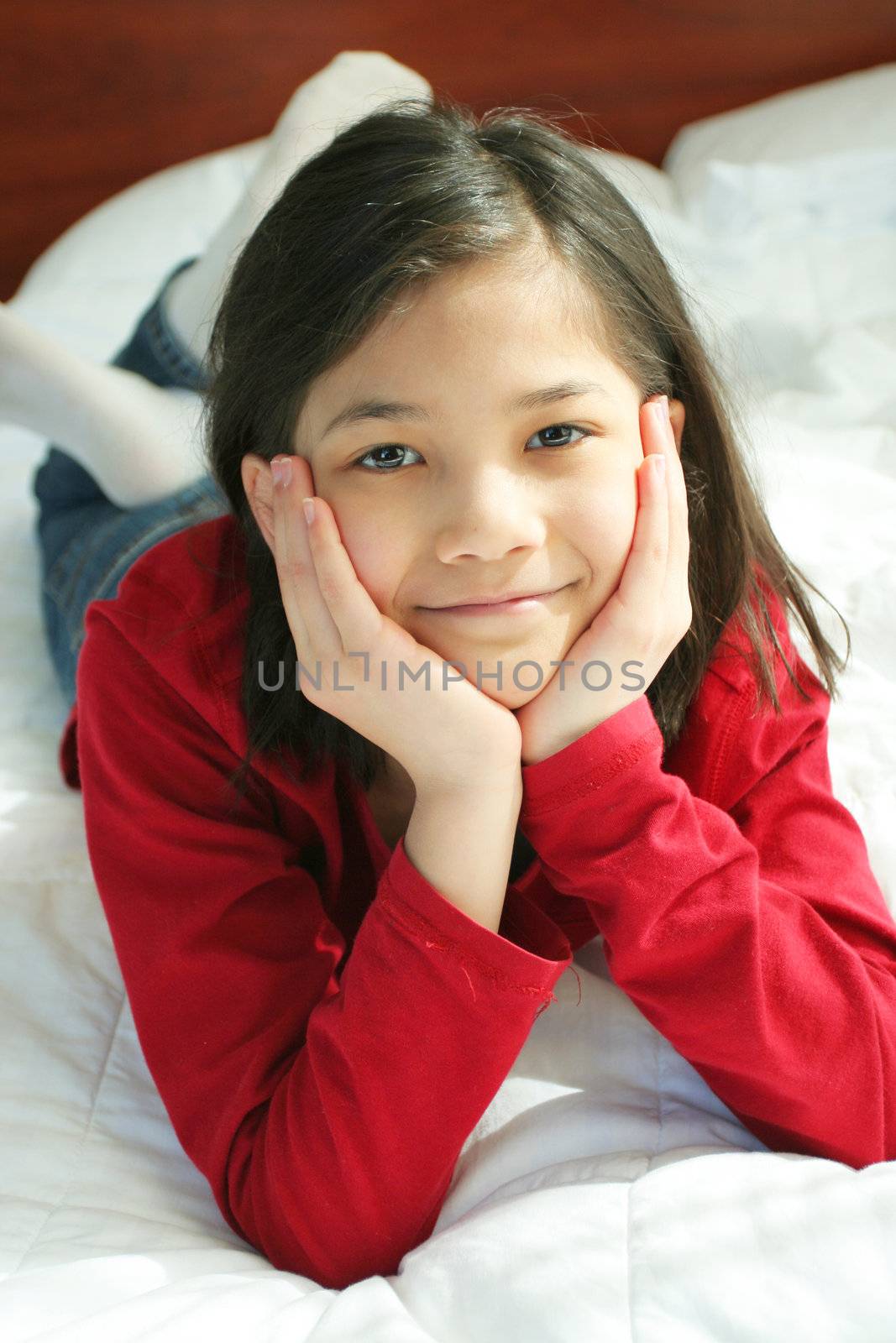 Child lying on bed thinking