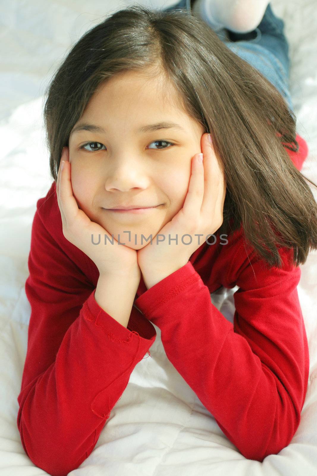 Child lying on bed thinking