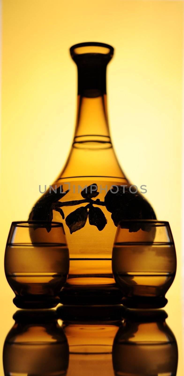 Elegant Crystal Decanter And Wine Glasses Over Yellow  Background.