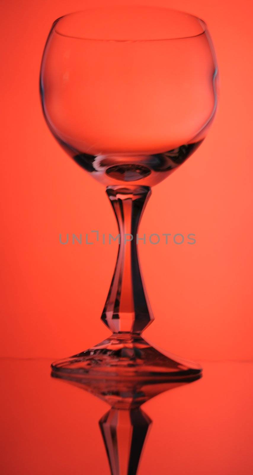 Elegant Crystal Wine Glass Over Red  Background.