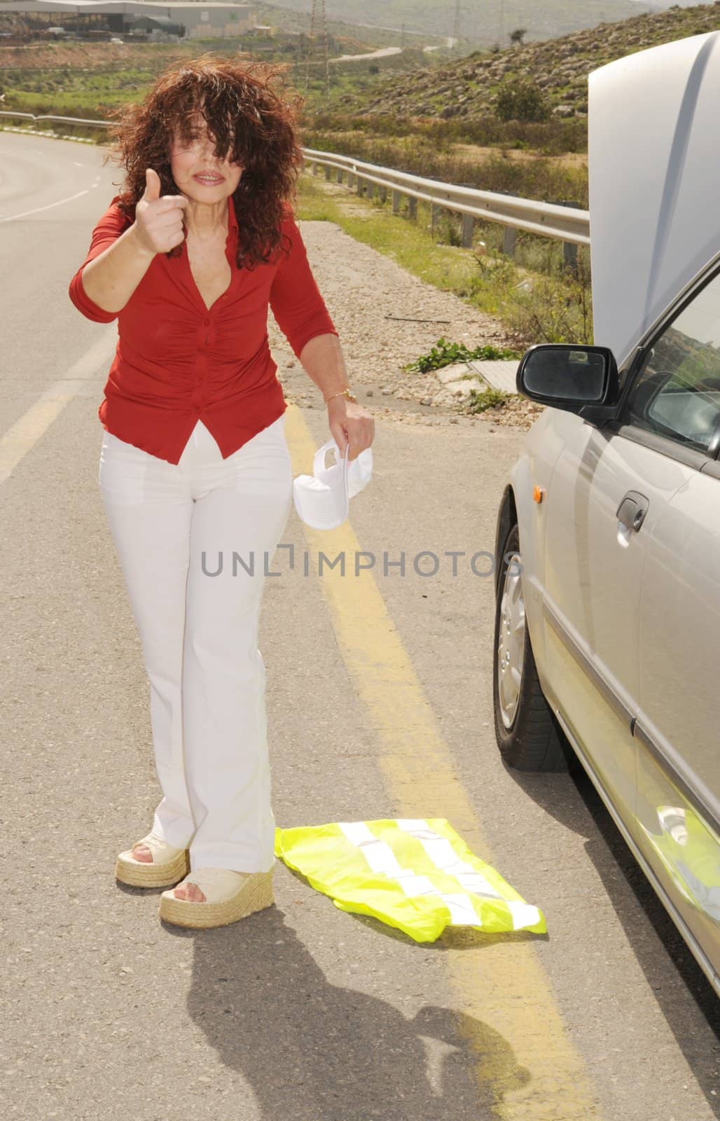 Despaired Elderly Woman Near Her Broken Down Car at the Side of the Road.