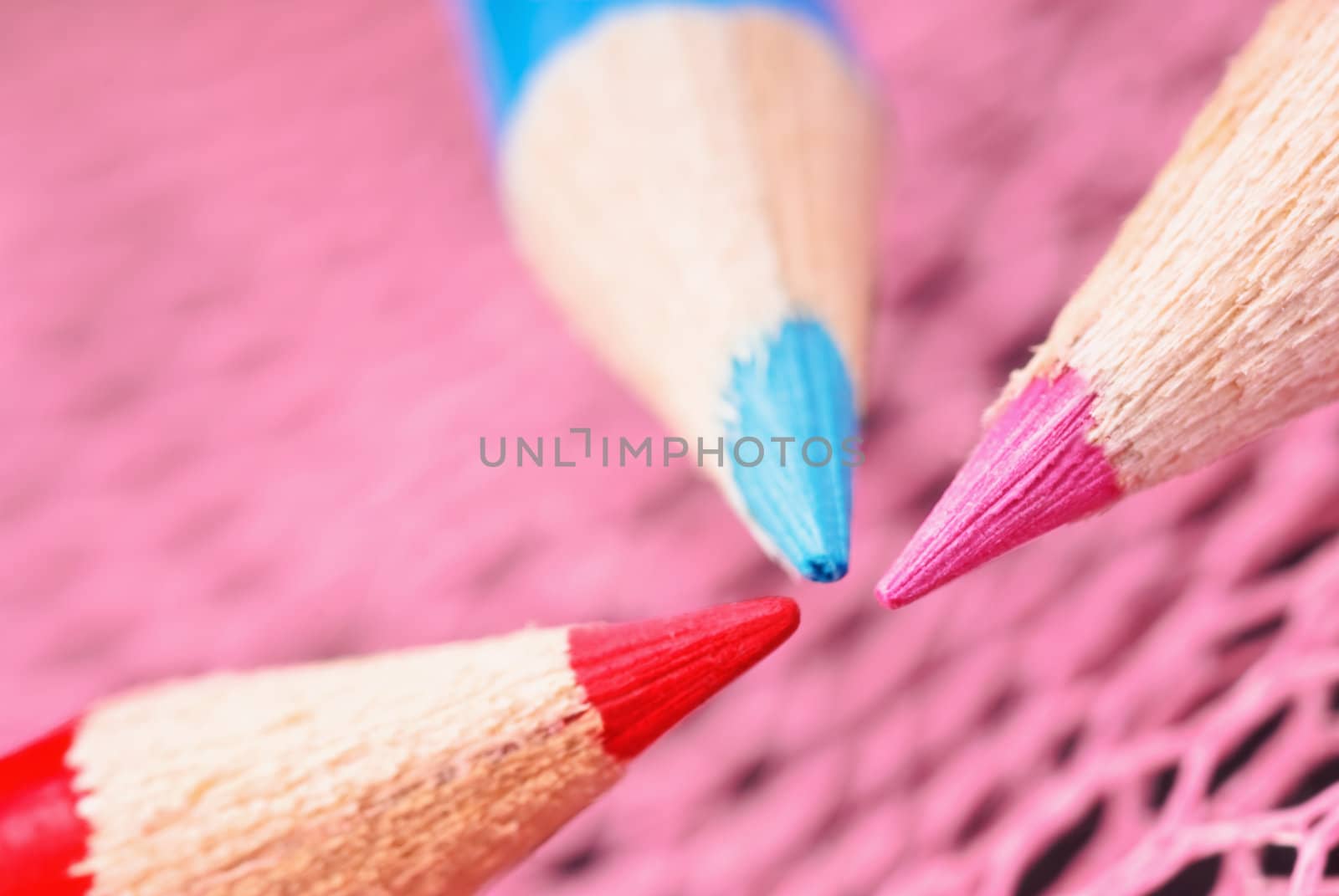 Three colored pencil close-up on a dark background