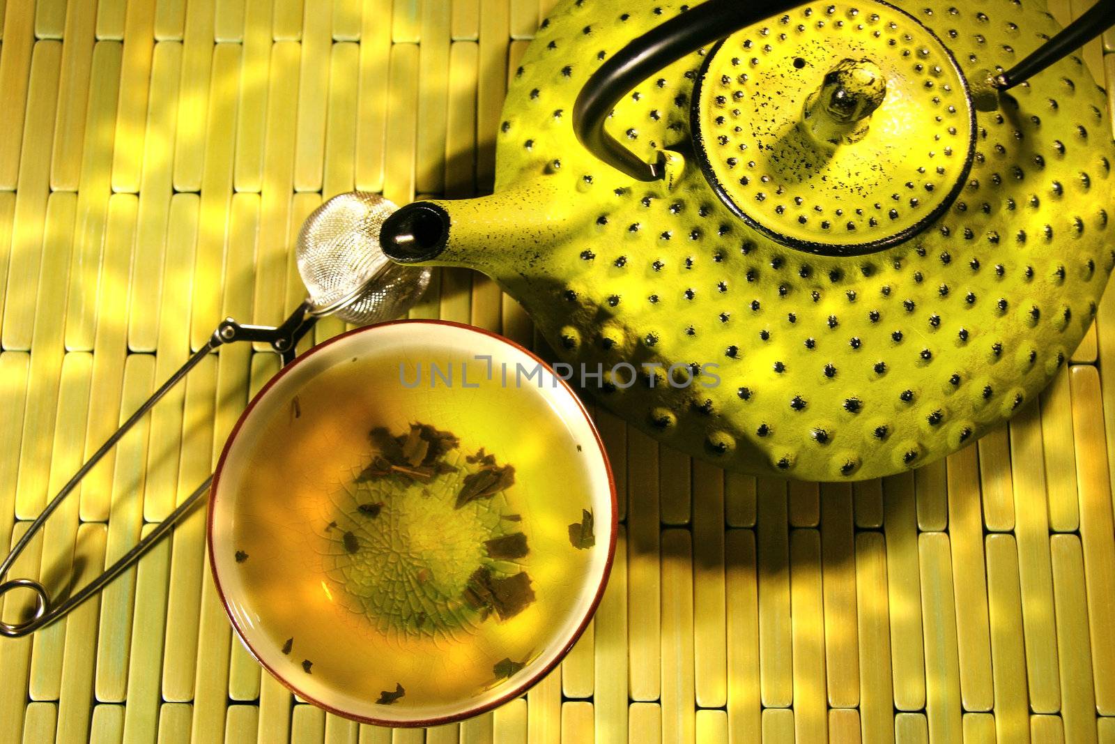Green asian teapot with cup and green tea
