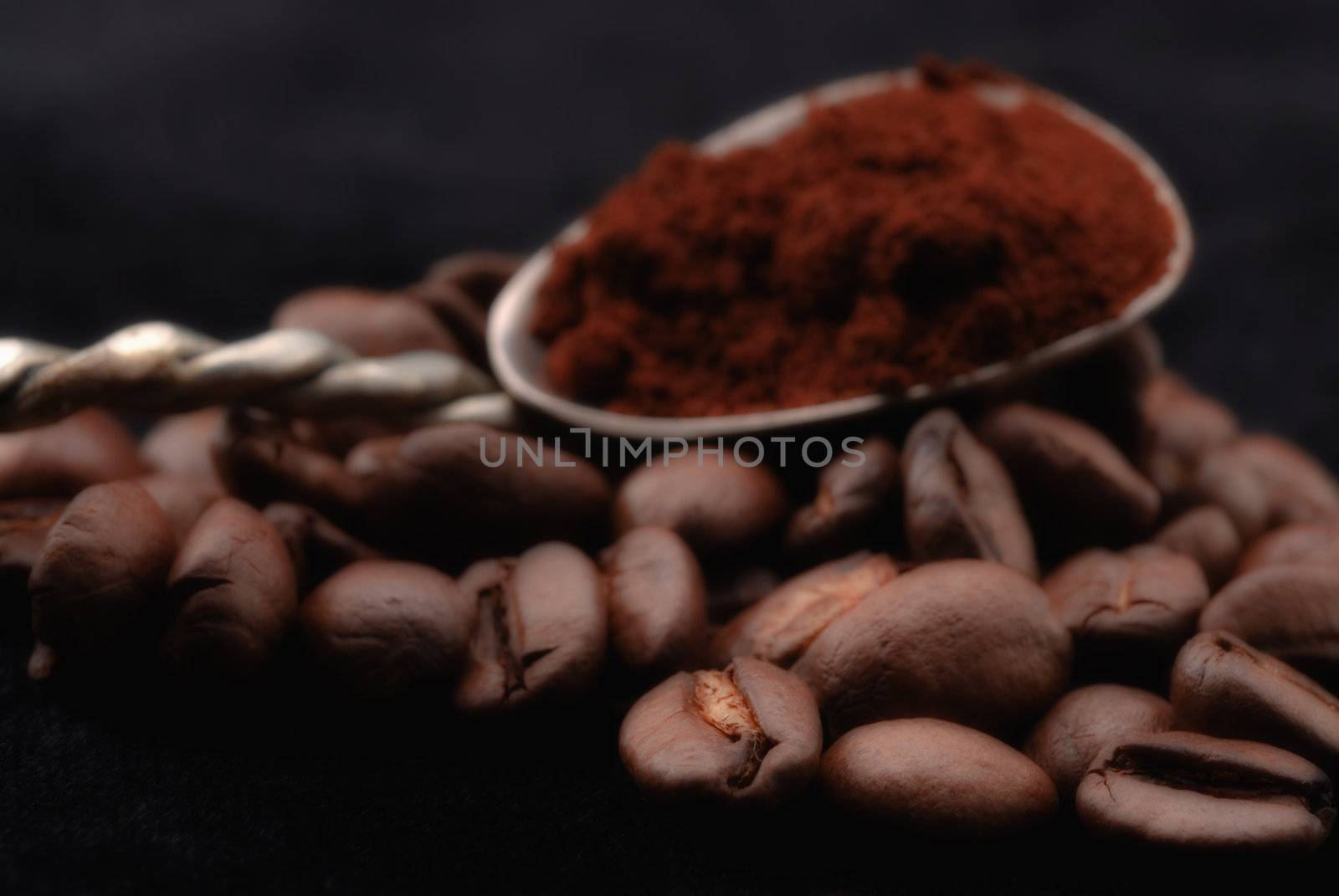 Coffee beans and ground coffee spoon