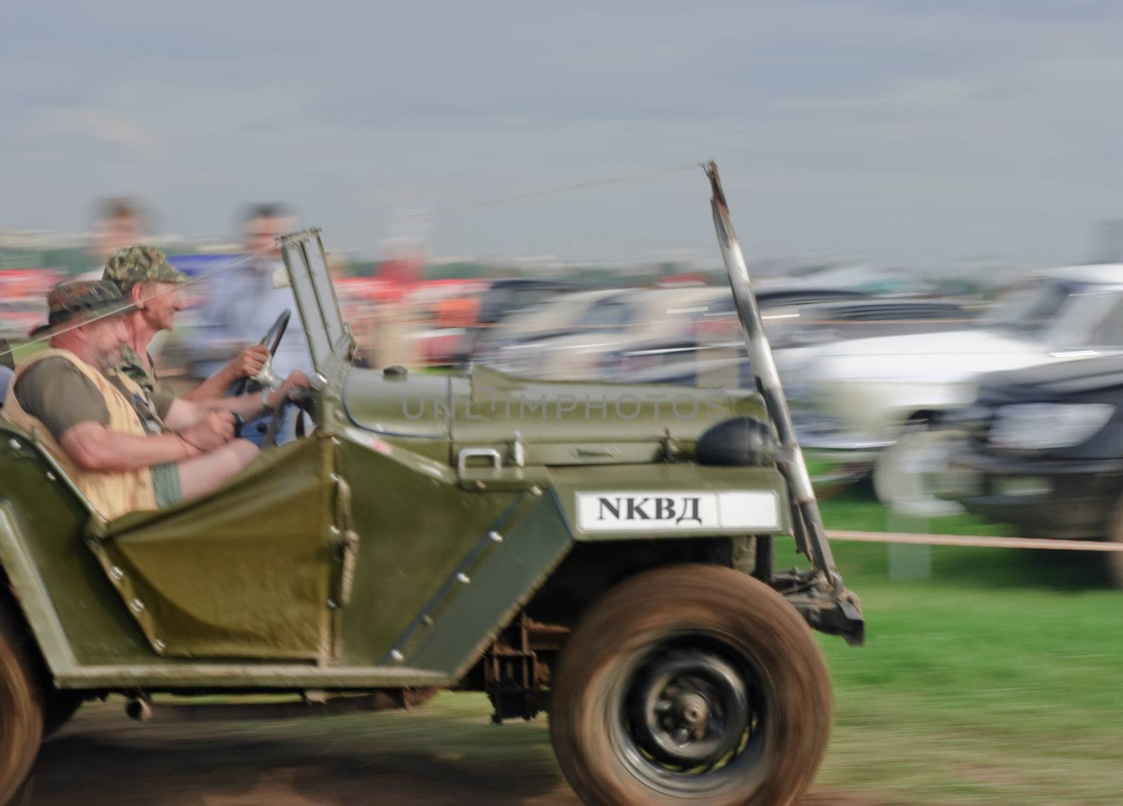 Vintage car moving at high speed against a backdrop of old cars