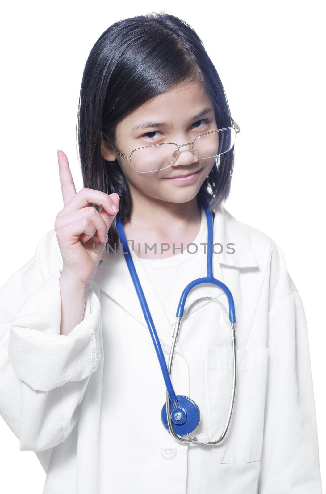 Nine year old girl playing doctor with white lab coat and stethoscope lifting finger sternly