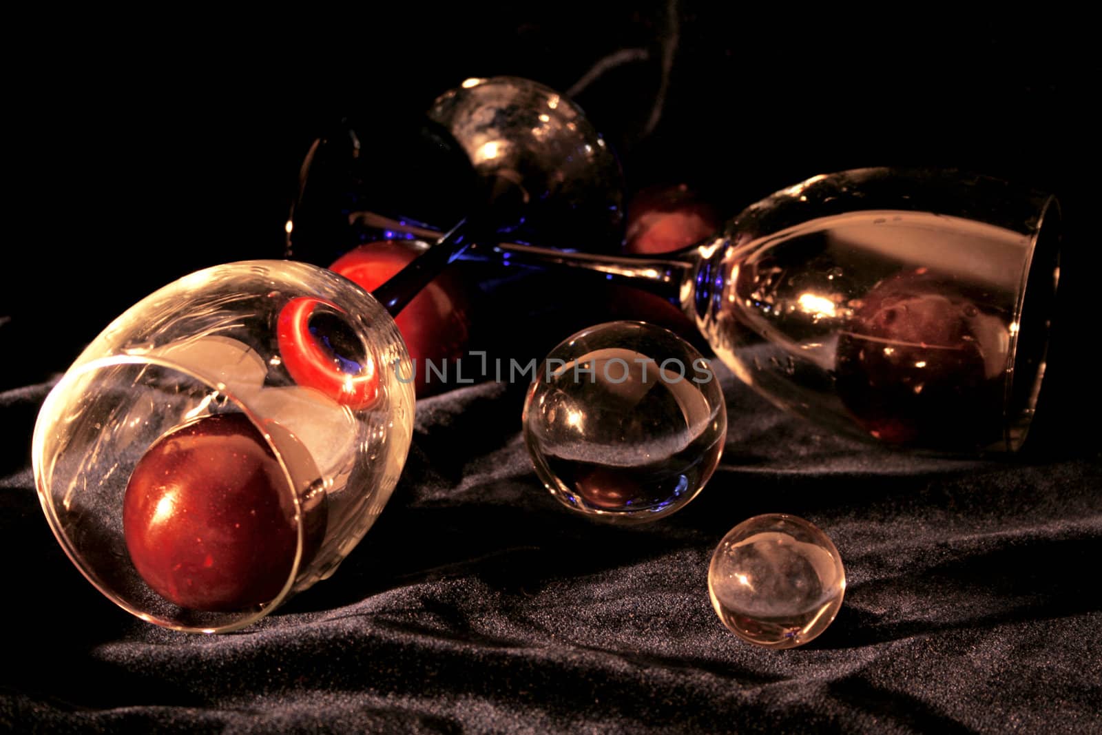 Glasses with plums both crystal and glass spheres on the black velvet