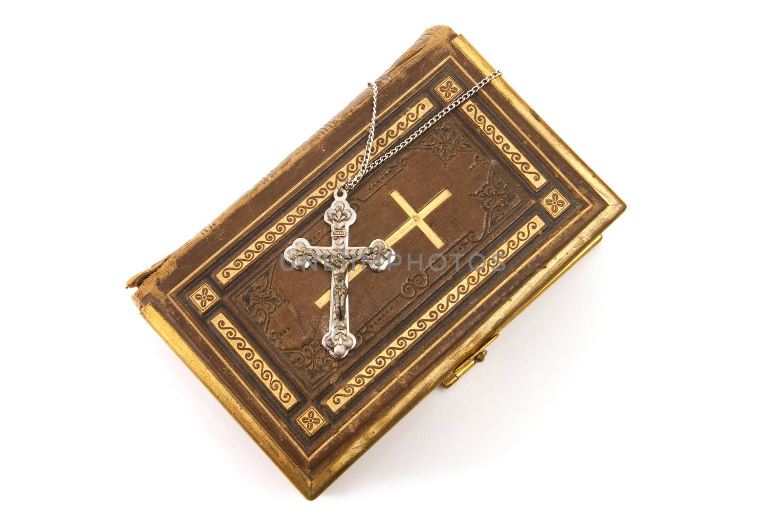 Cross on a antique Christian book with the cross symbol on the cover, isolated on white background