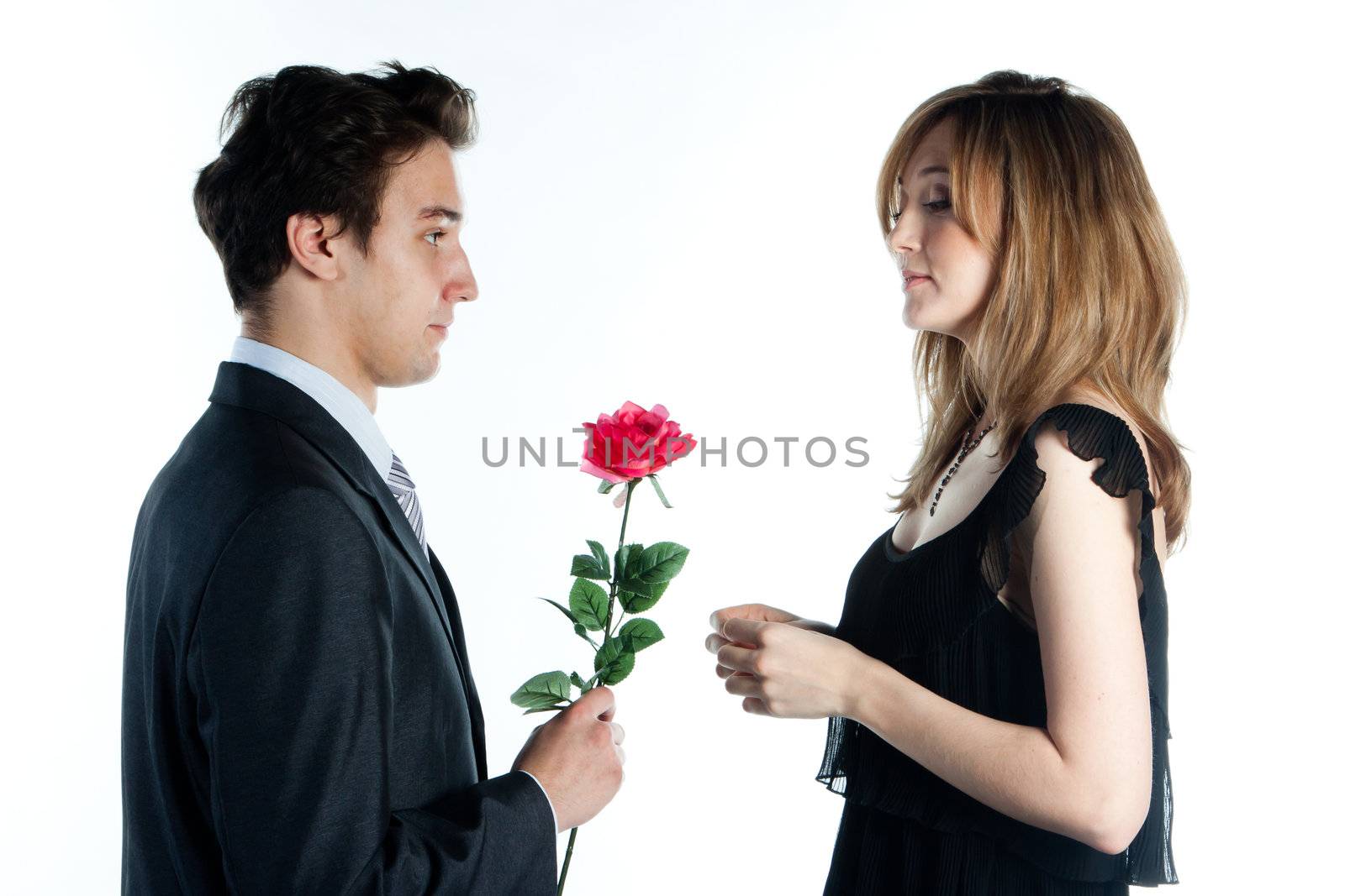 A young man gives a beautiful young woman, a flower in honor of the holiday