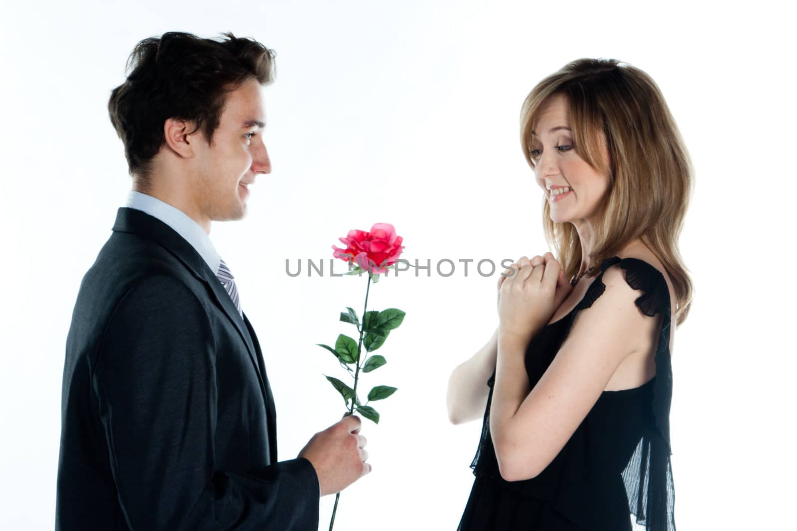 A young man gives a beautiful young woman, a flower in honor of the holiday