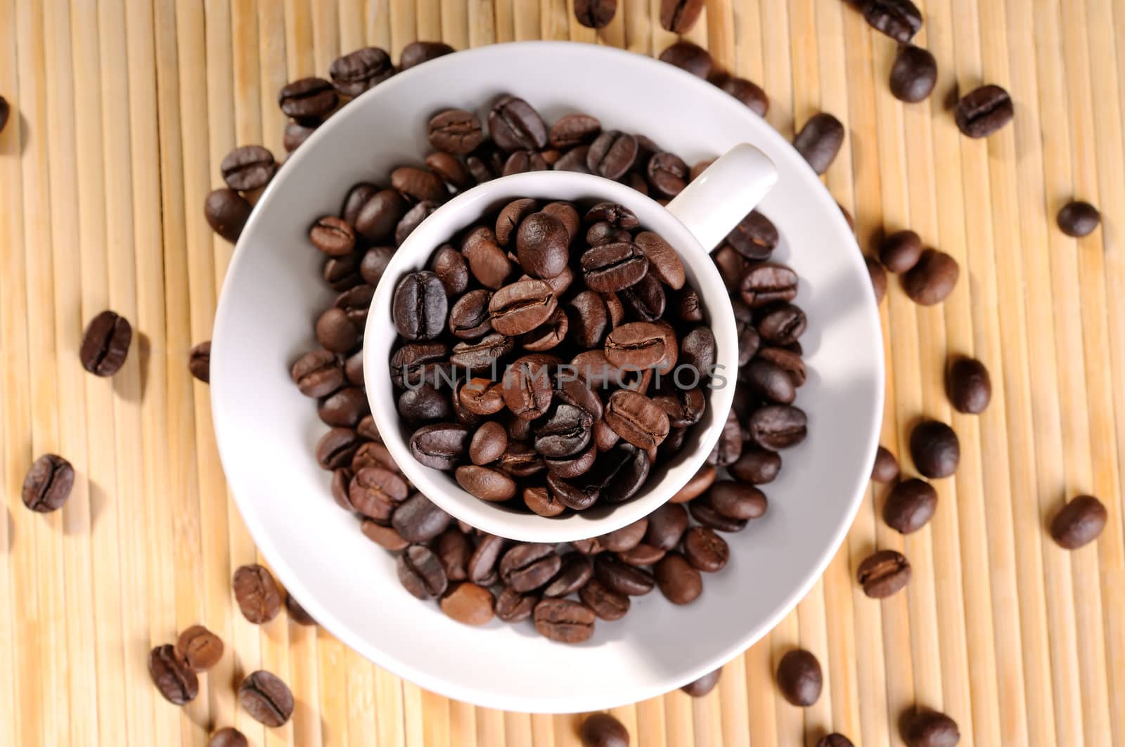 Cup of coffee surrounding with coffee beans