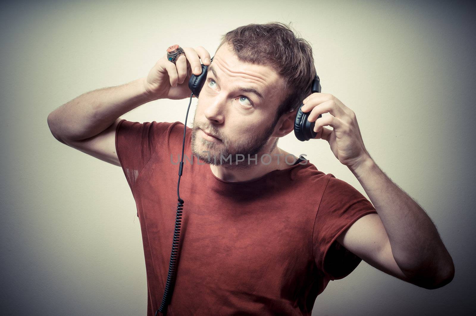 vintage portrait of fashion guy with headphones on gray background