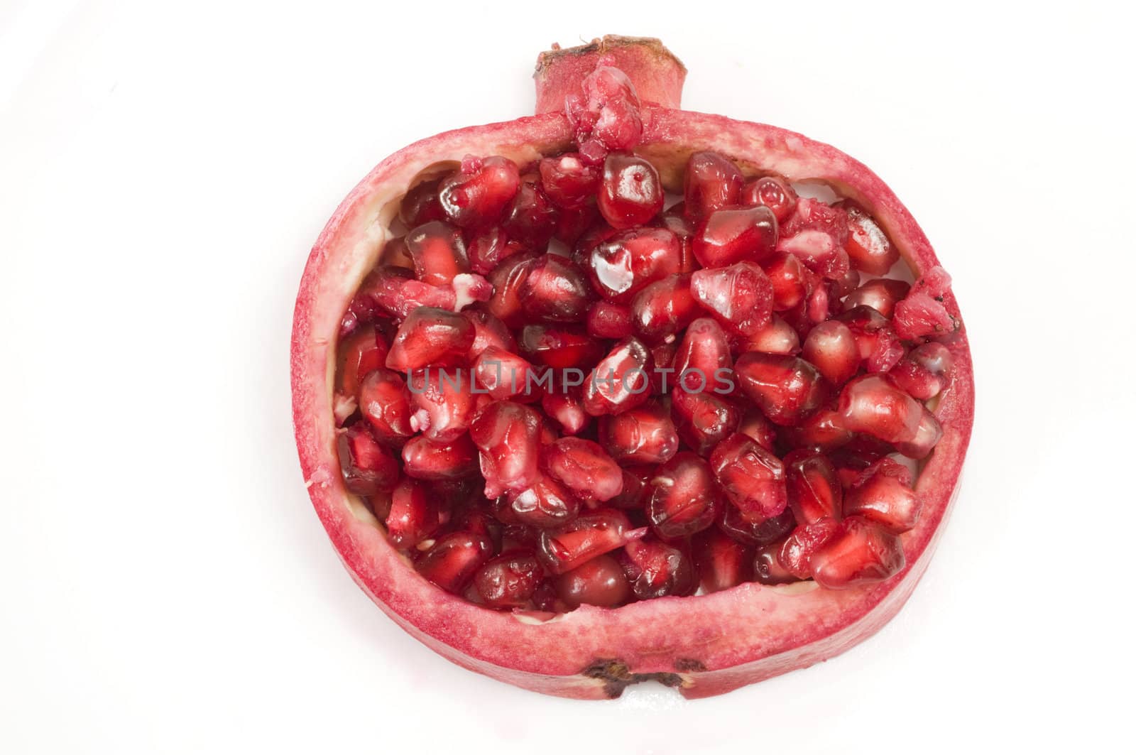 Portion of a pomegranate shell holding the vibrant red berries