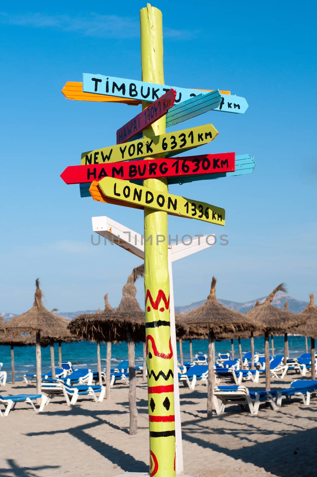 Many chaise longes and sign on the beach