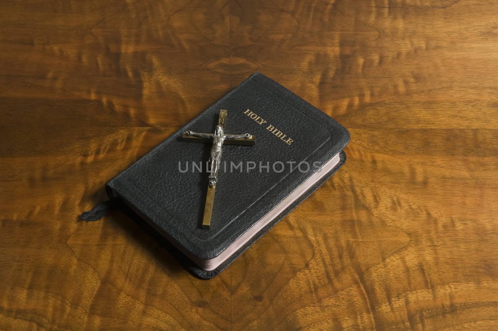 Cross and bible on an antique wood table top.