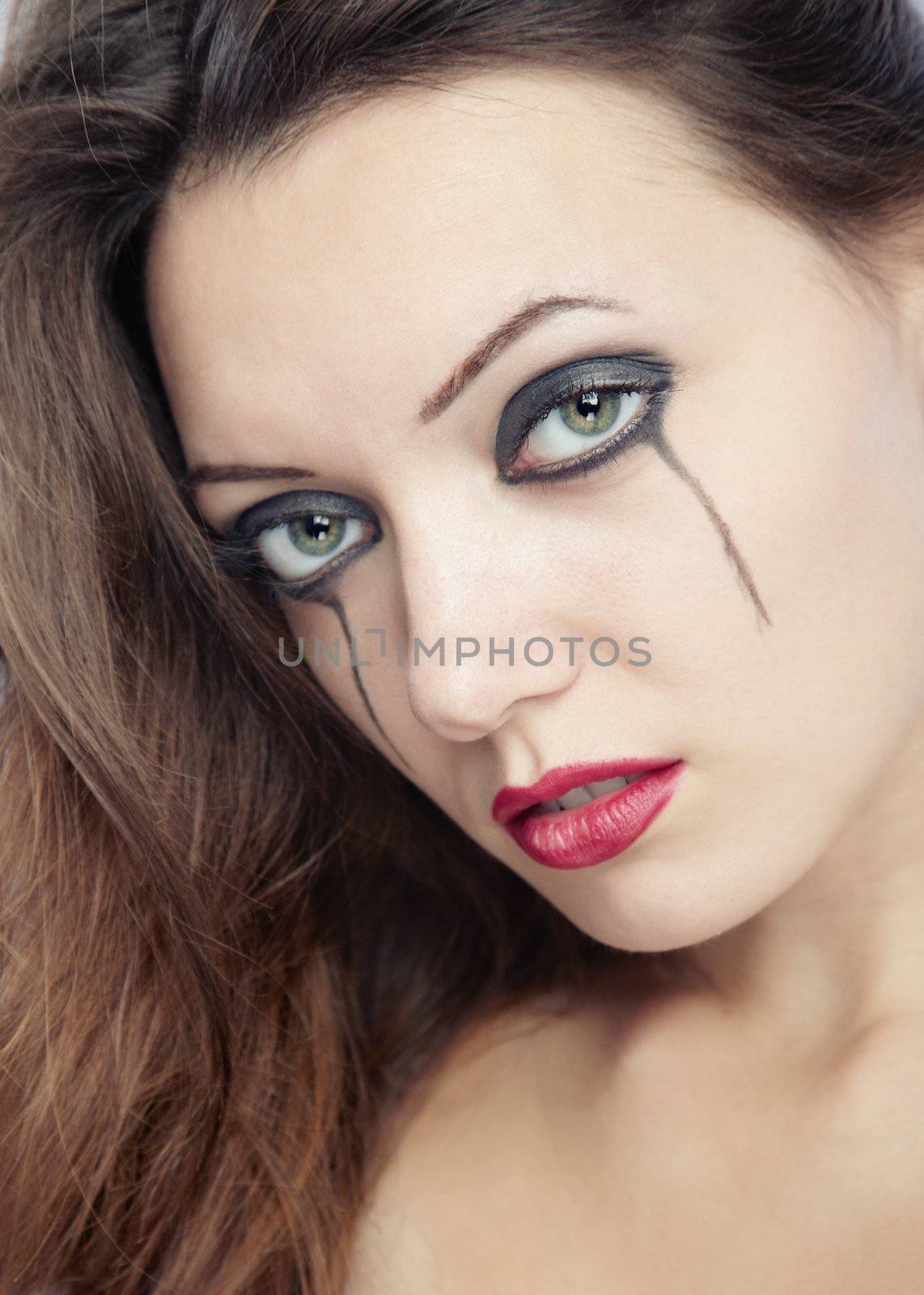 Sad woman with odd makeup. Close-up portrait with natural colors 