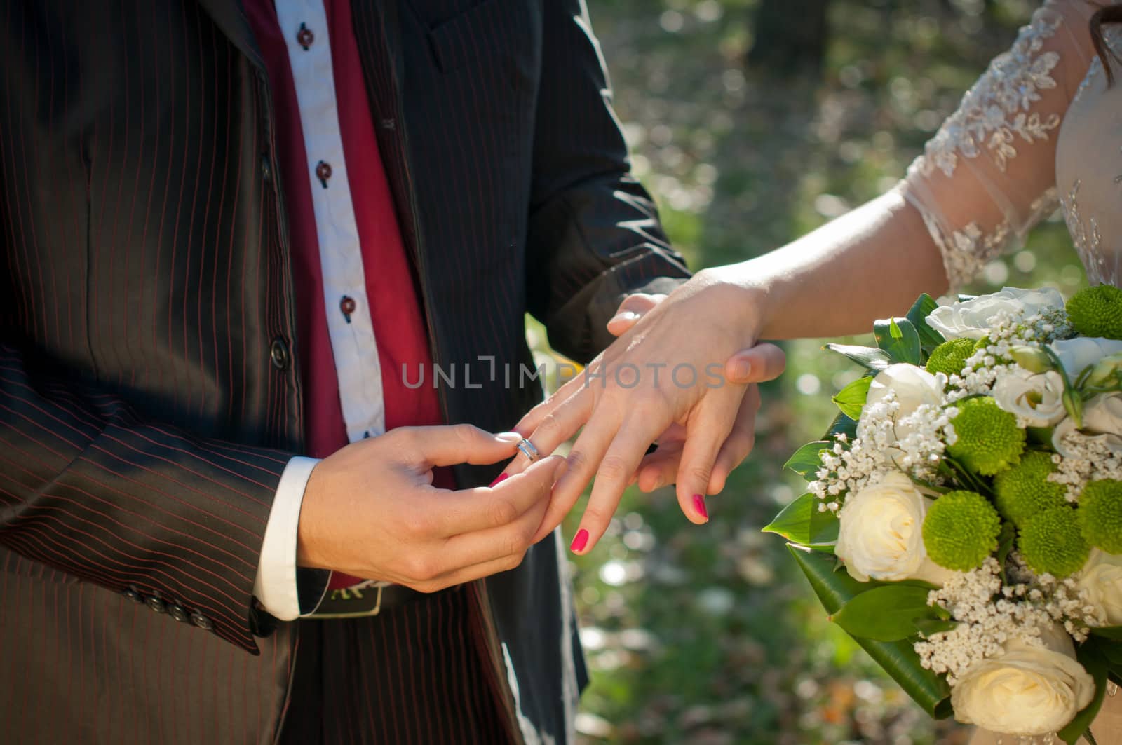 Wedding ceremony moment where the groom places the wedding ring on the brides finger.