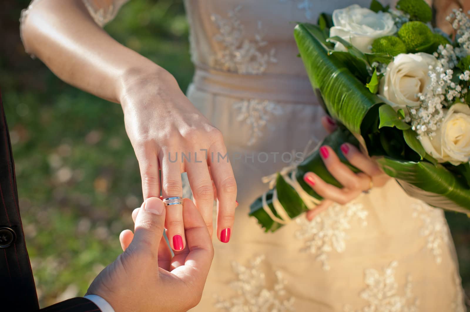 Wedding ceremony moment where the groom places the wedding ring on the brides finger.