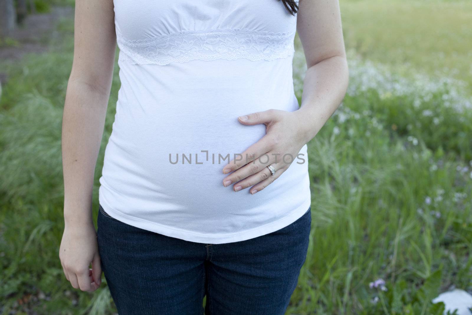 Mother 5 months pregnant with left hand on belly.