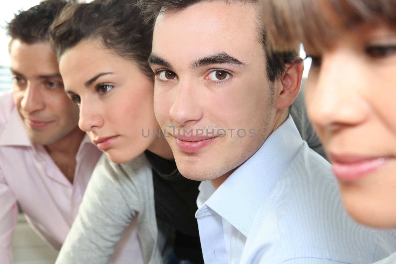 Closeup of people's faces in an office by phovoir
