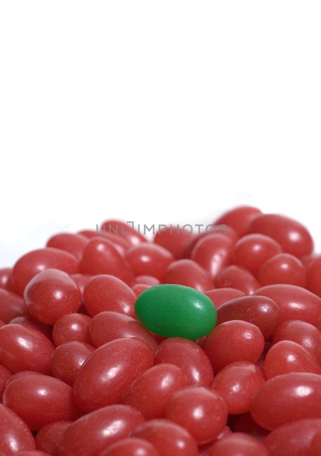 Green jelly bean with many red jelly beans