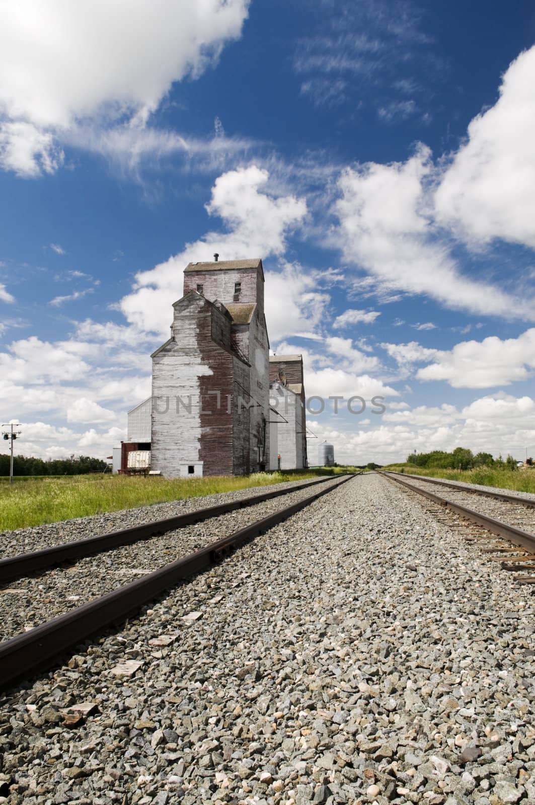 Old grain elevator located in rural Saskatchewan with railway line perspective