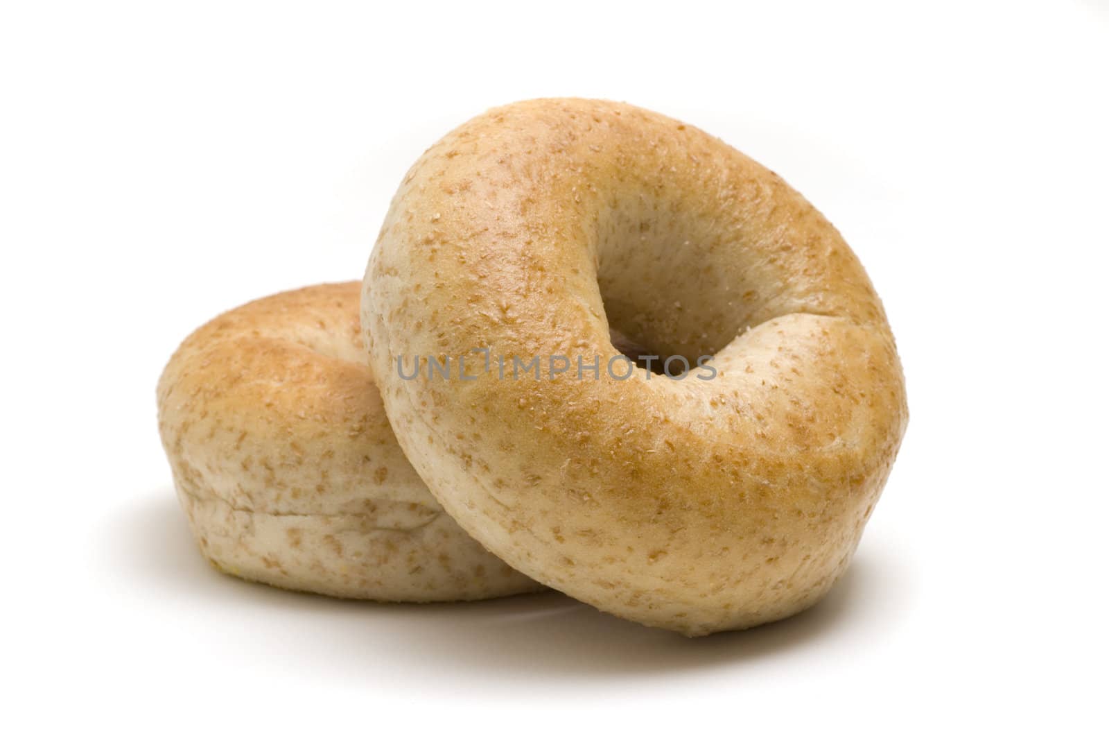 Two whole wheat bagels isolated on white background.
