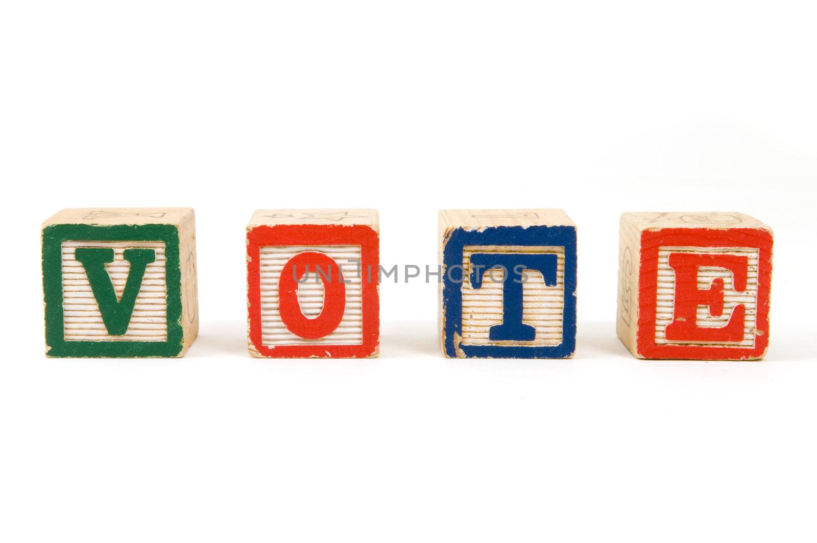 Children's blocks spelling VOTE on a white background