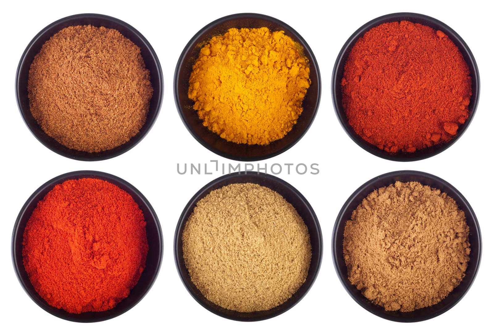 collection of indian spices (cumin, coriander, paprika, garam masala, curcuma, chili powder) on black ceramic cups isolated on white background