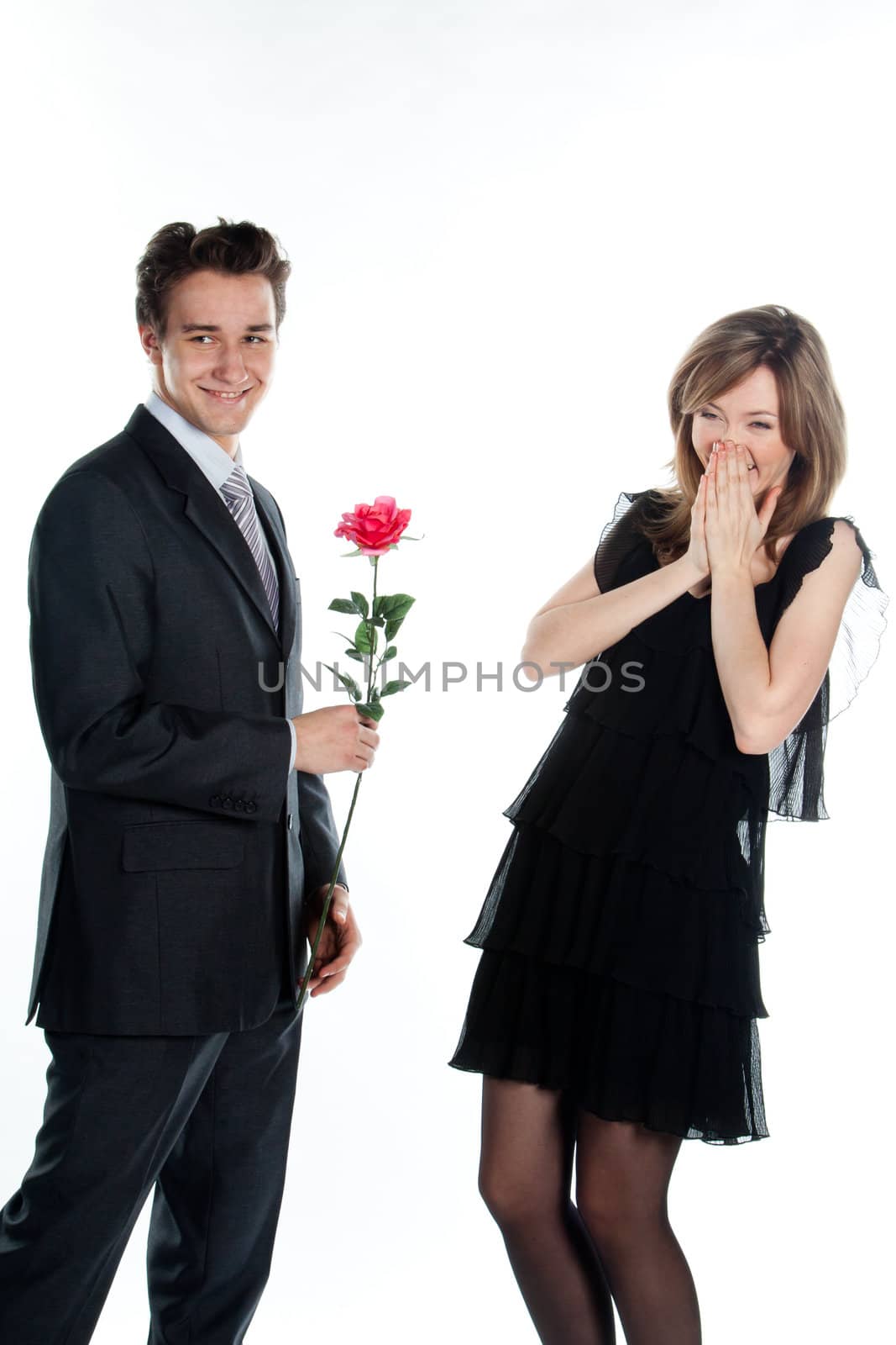 A young man gives a beautiful young woman, a flower in honor of the holiday