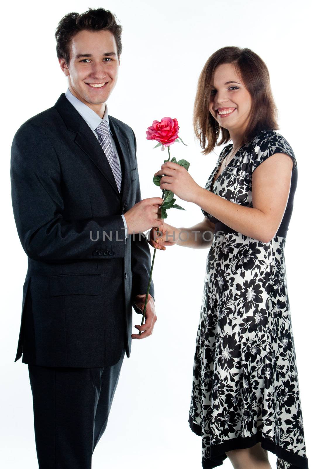 A young man gives a beautiful young woman, a flower in honor of the holiday