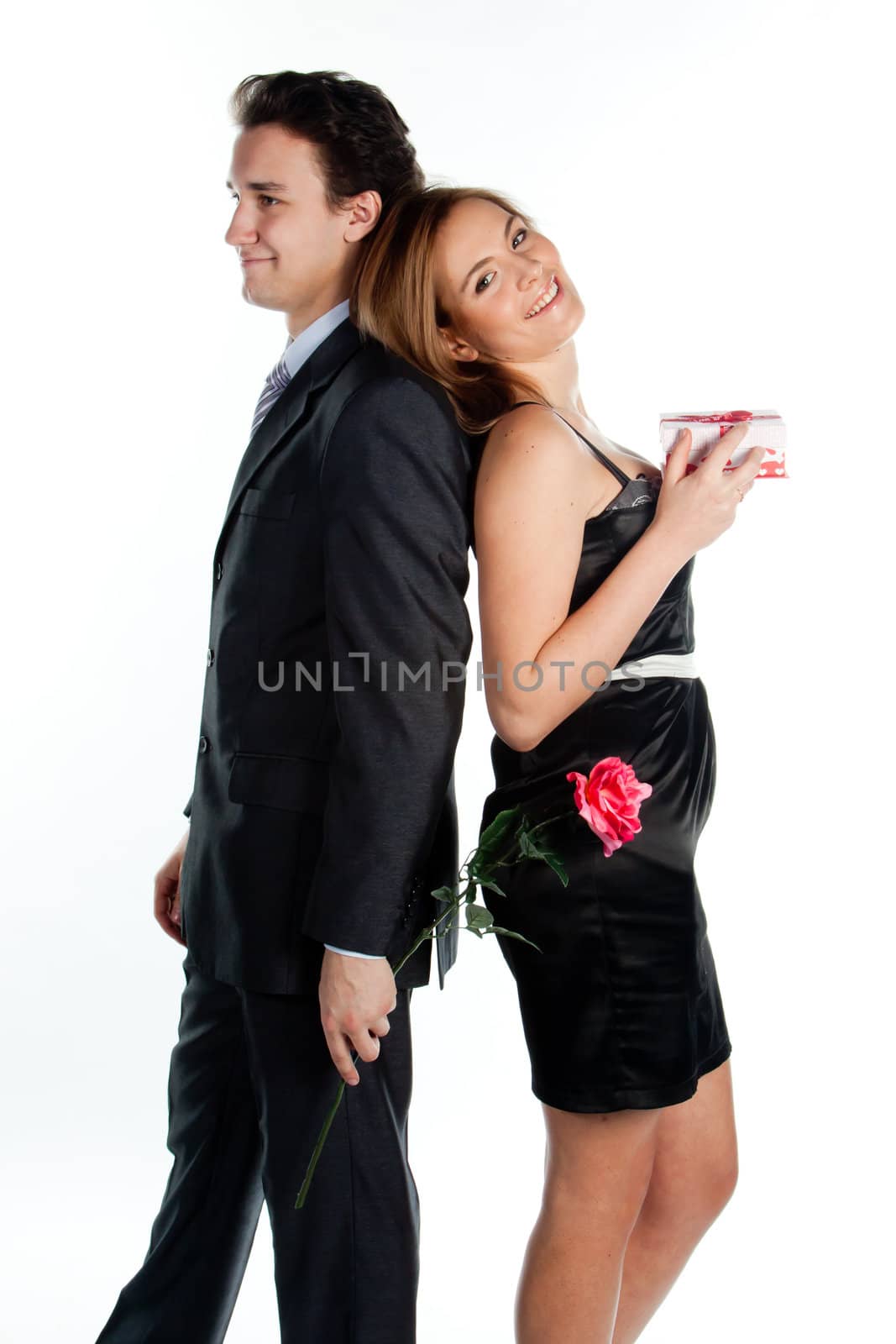 A young man gives a beautiful young woman, a flower in honor of the holiday
