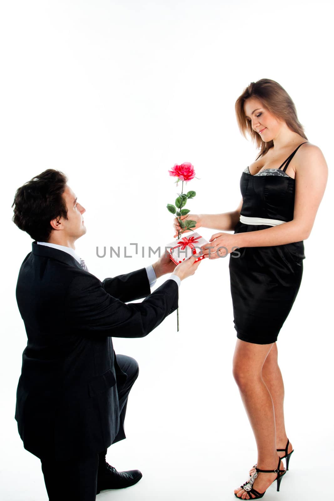 A young man gives a beautiful young woman, a flower in honor of the holiday