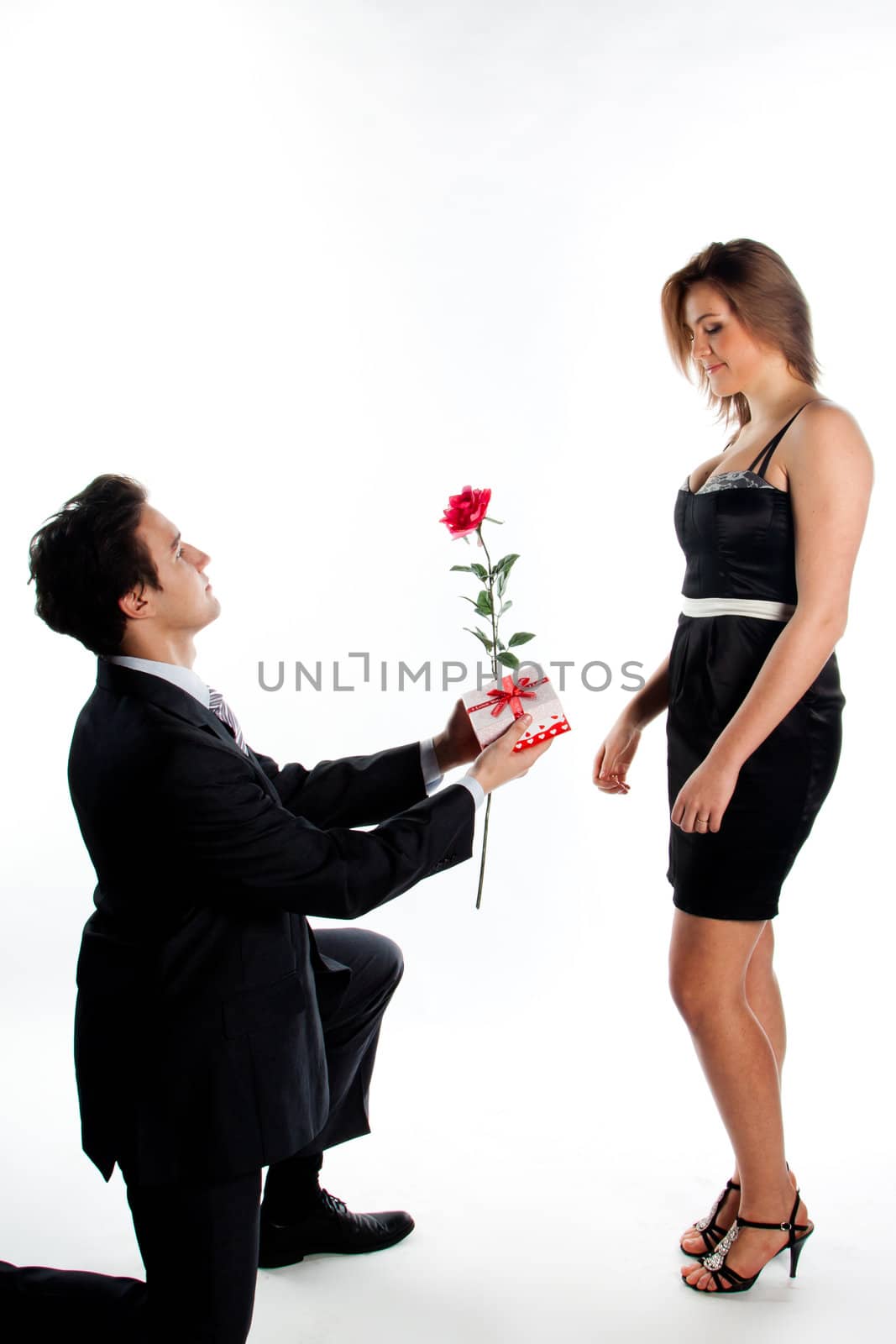 A young man gives a beautiful young woman, a flower in honor of the holiday