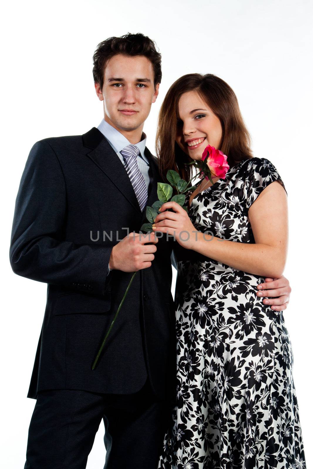 A young man gives a beautiful young woman, a flower in honor of the holiday