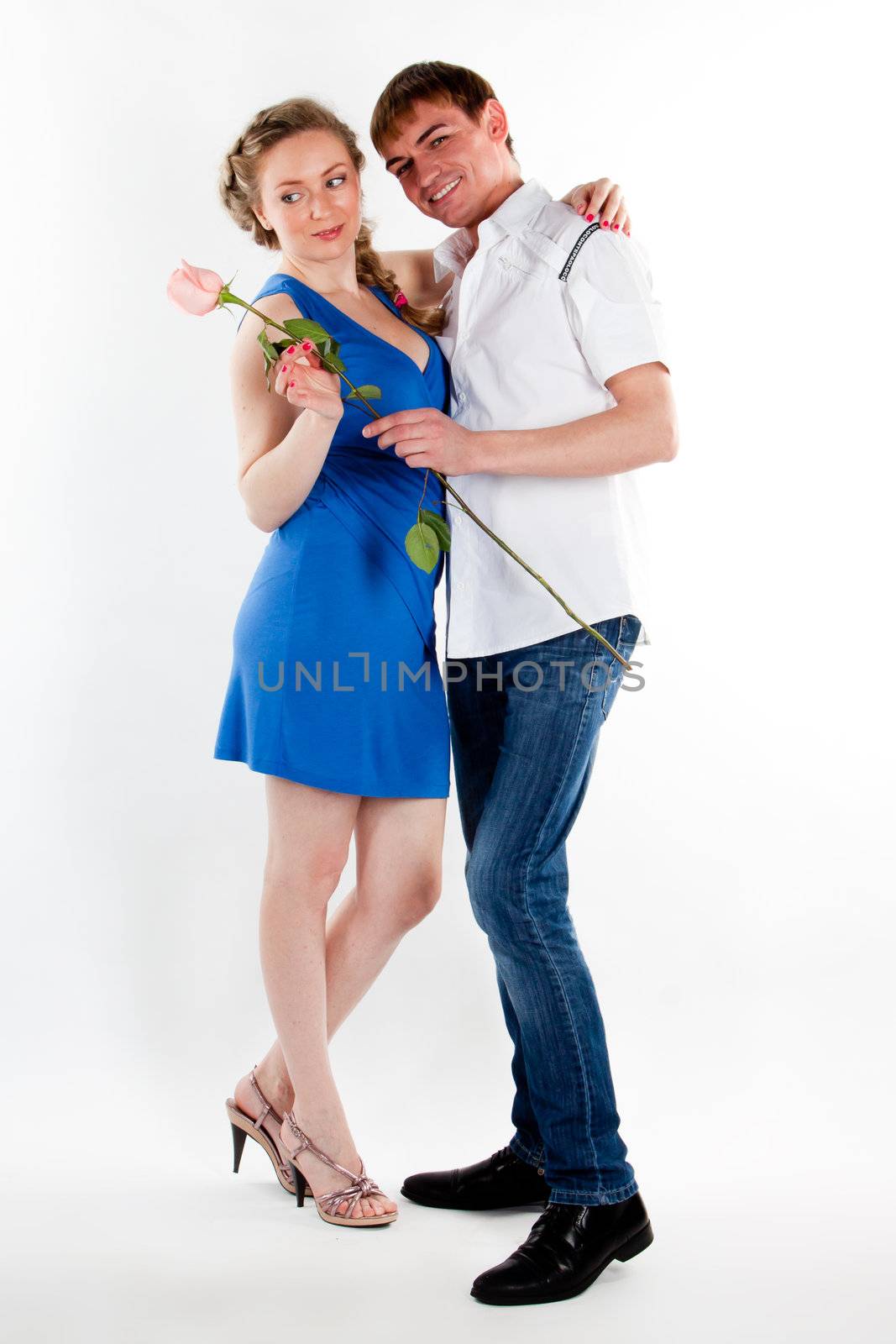 A young man gives a beautiful young woman, a flower in honor of the holiday