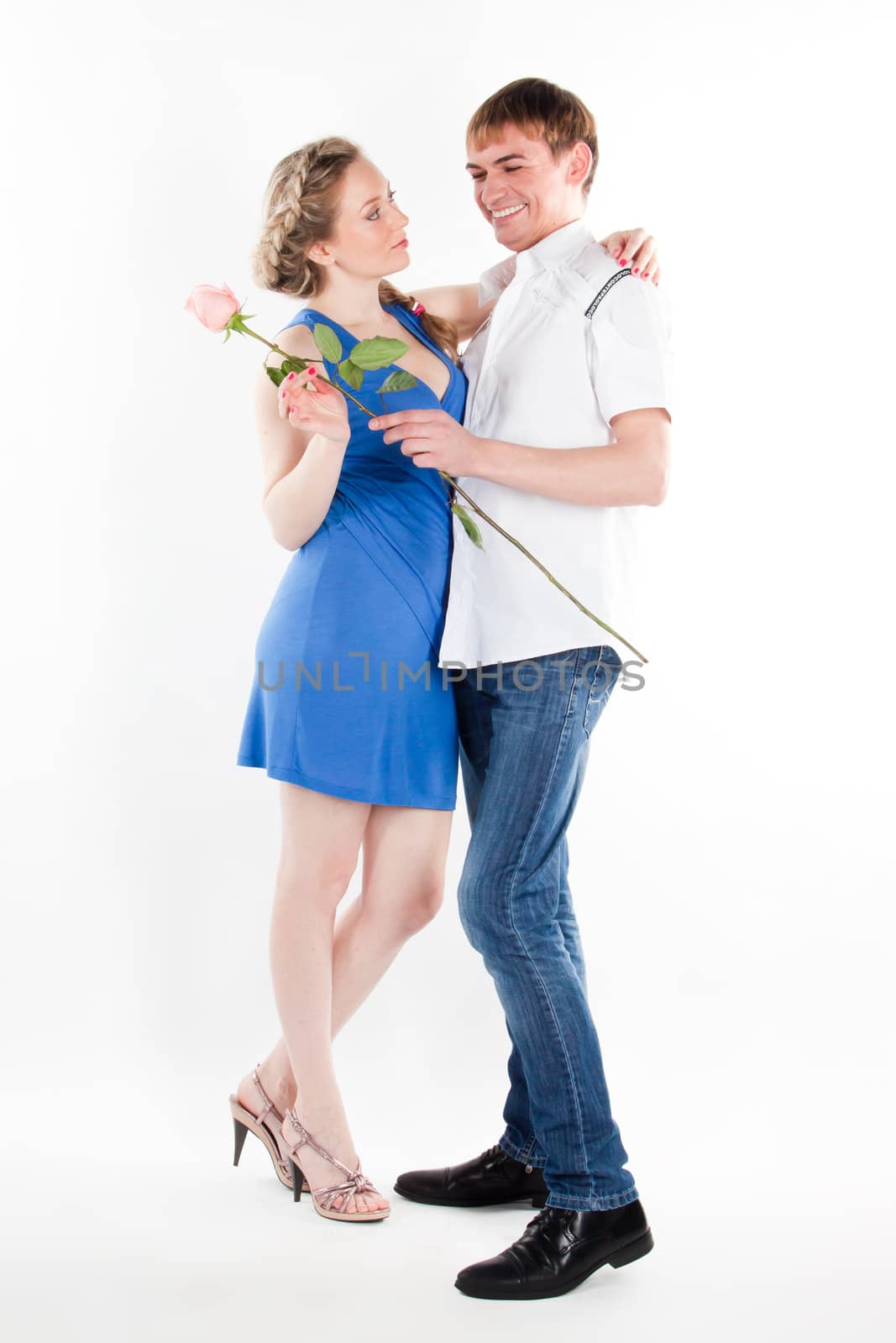 A young man gives a beautiful young woman, a flower in honor of the holiday